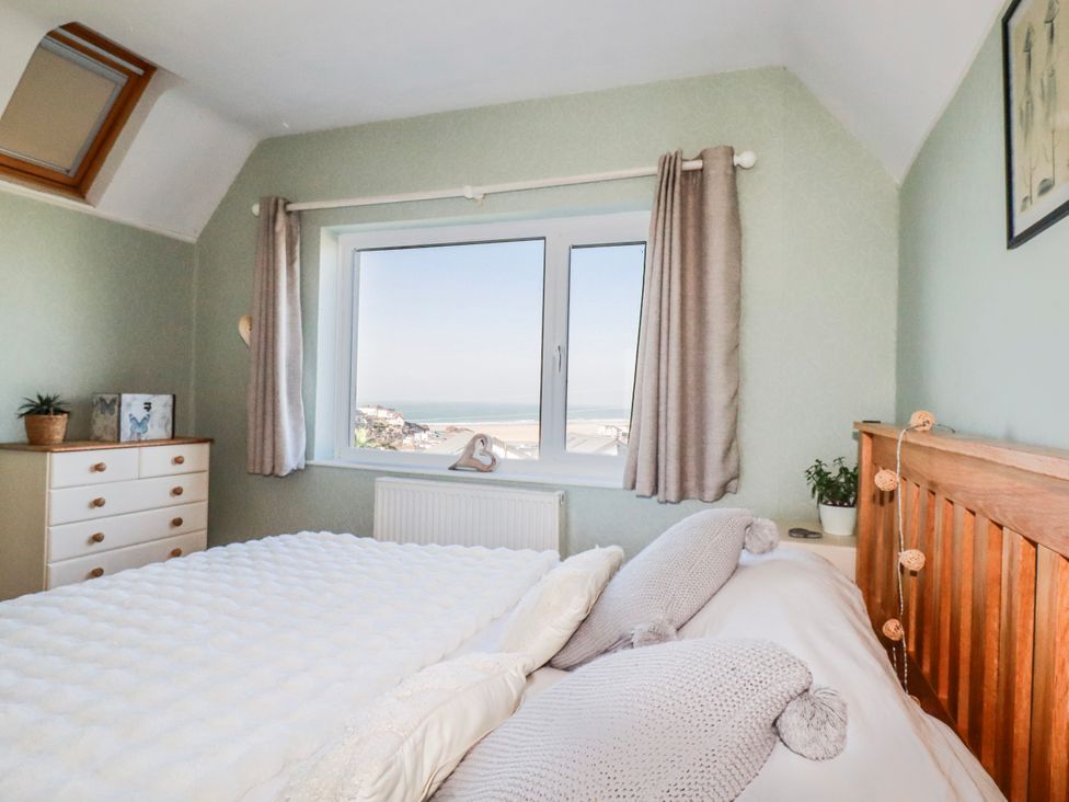 A bedroom with a window and a plant at 3A Grannys Lane, Perranporth