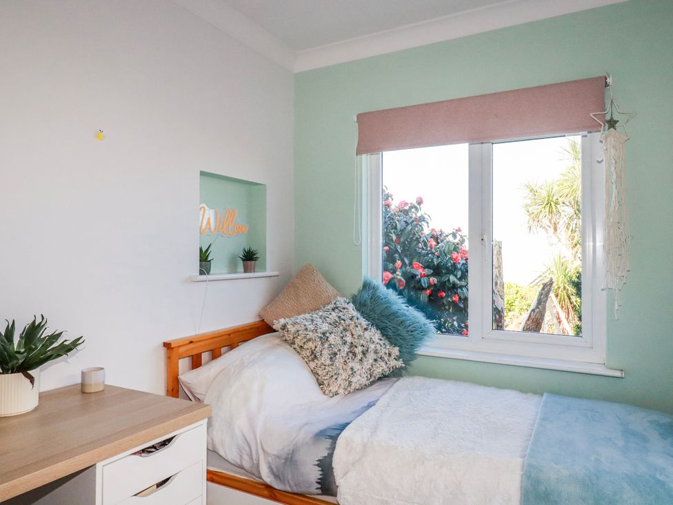 A bedroom with a bed and window at 3A Grannys Lane in Perranporth