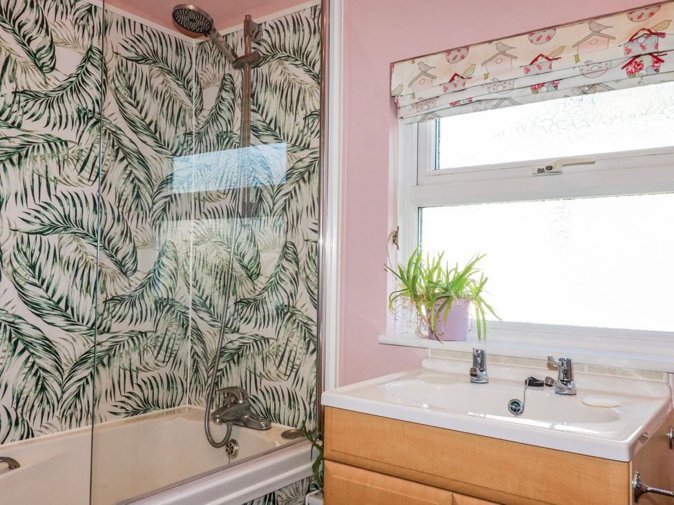 A bathroom with a bathtub and sink at 3A Grannys Lane Perranporth