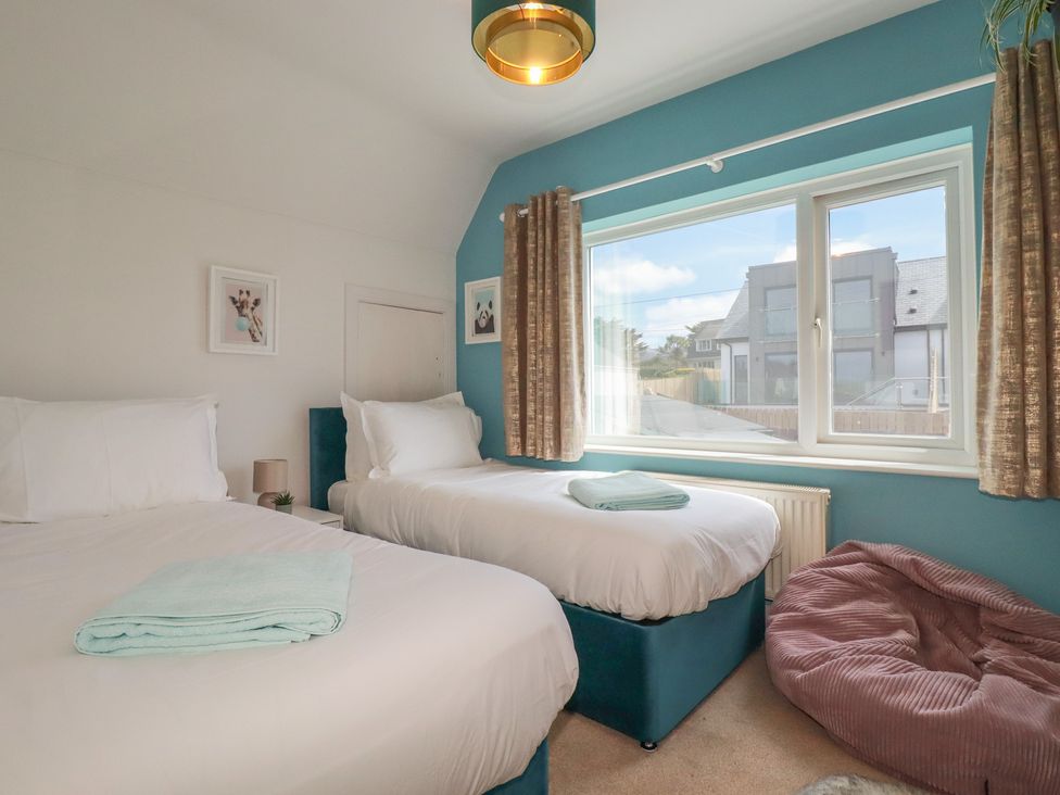 A bedroom with two beds and a window at 3A Grannys Lane Perranporth