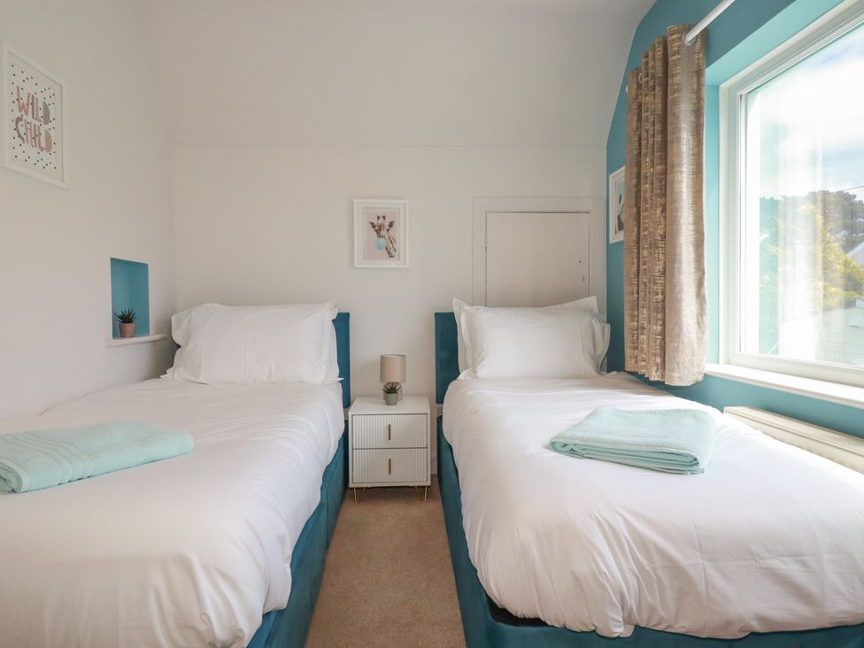 A bedroom with two beds and a window at 3A Grannys Lane Perranporth