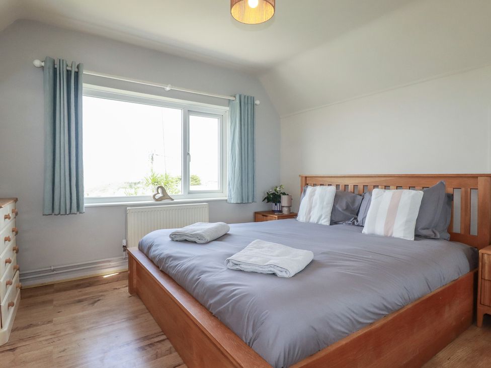 A bedroom with a bed and nightstands at 3A Grannys Lane Perranporth