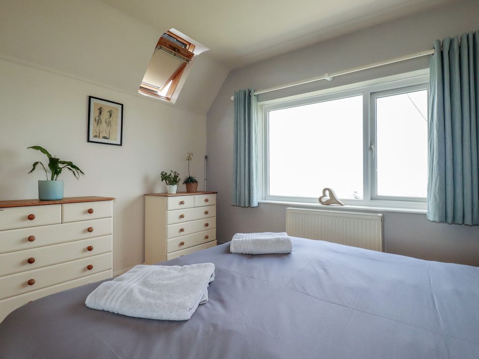 A bedroom with a bed and dressers at 3A Grannys Lane Perranporth