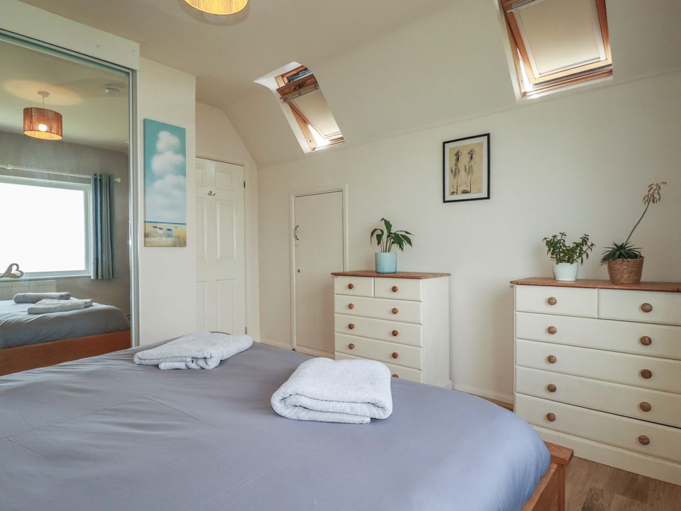 A bedroom with a bed and dressers at 3A Grannys Lane, Perranporth
