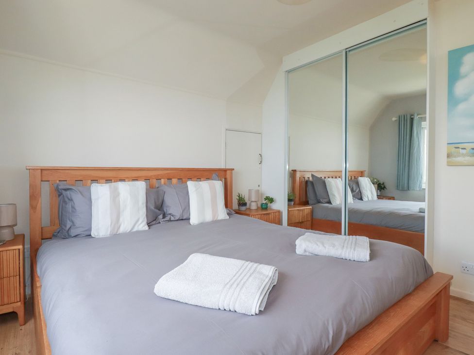 A bedroom with a bed and a lamp at 3A Grannys Lane in Perranporth