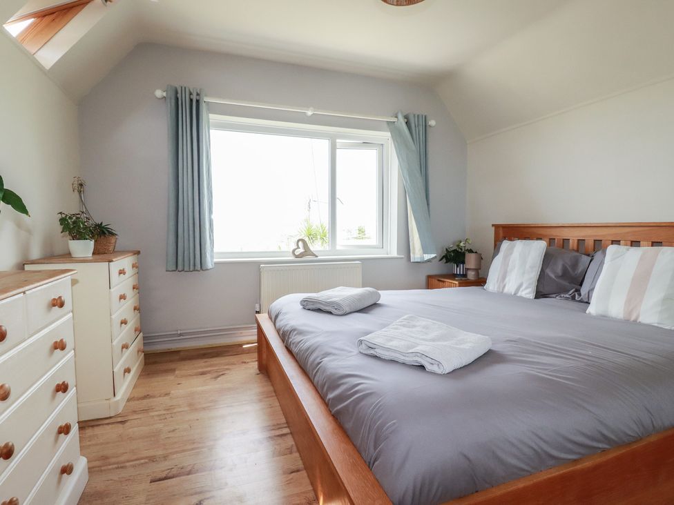A bedroom with a bed and window at 3A Grannys Lane in Perranporth