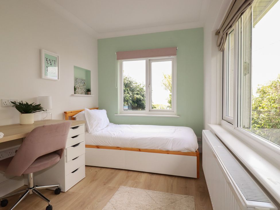 A bedroom with a bed and desk at 3A Grannys Lane, Perranporth