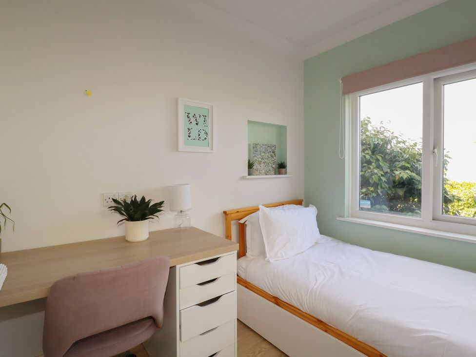 A bedroom with a bed and desk at 3A Grannys Lane Perranporth