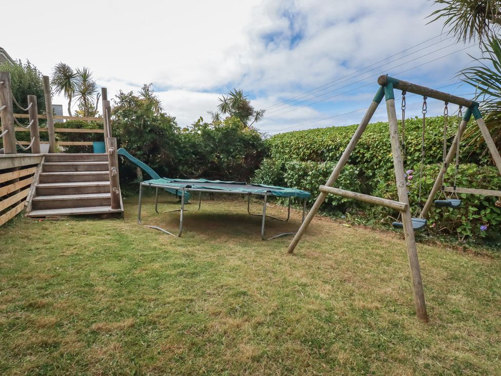 A garden with a trampoline and swing set at 3A Grannys Lane Perranporth
