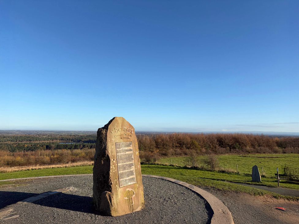 A stone monument with text engraving and landscape view at Cheshire