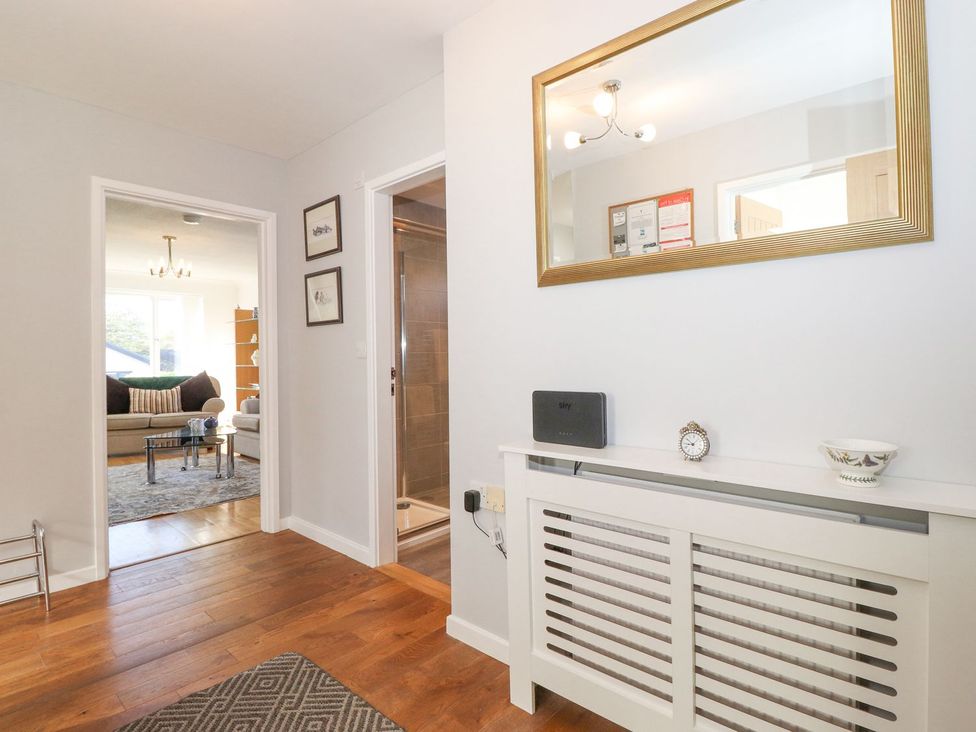A hallway with a mirror and radiator at Wansfell View in Ambleside