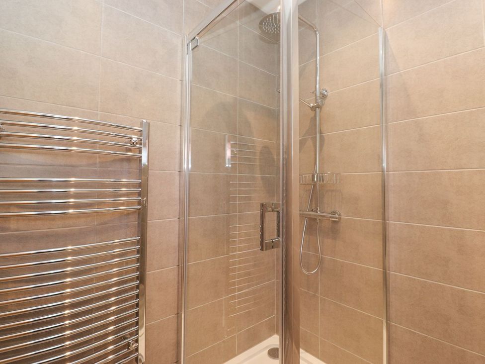 A shower with glass door and towel rail at Wansfell View in Ambleside