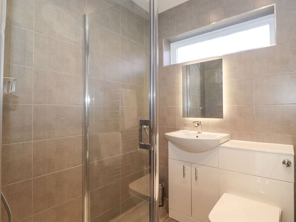 A bathroom with a shower, sink, and toilet at Wansfell View in Ambleside