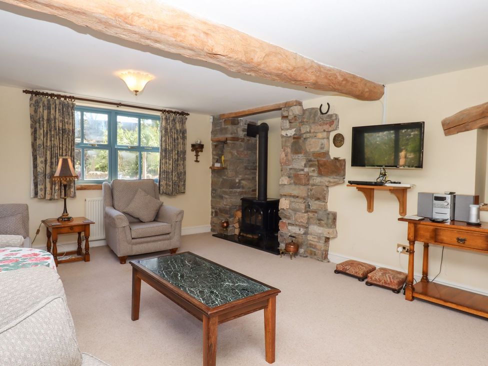 A living room with a fireplace and television at Pillars Barnstaple