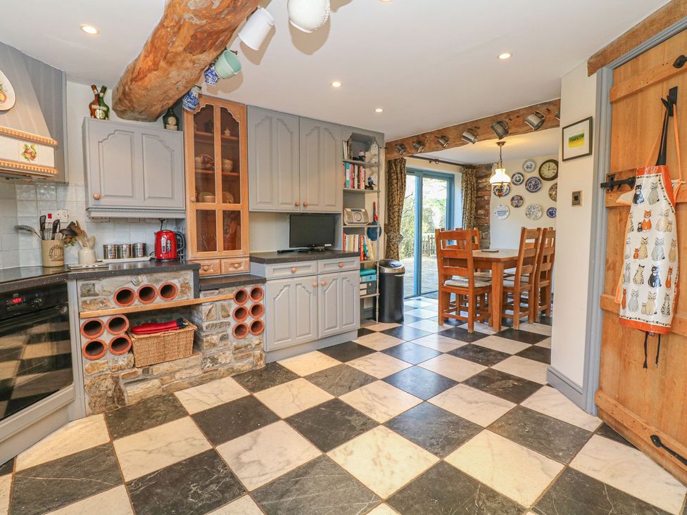 A kitchen with cabinets and a dining area at Pillars in Barnstaple