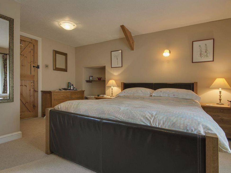 A bedroom with a bed and nightstands at Pillars in Barnstaple