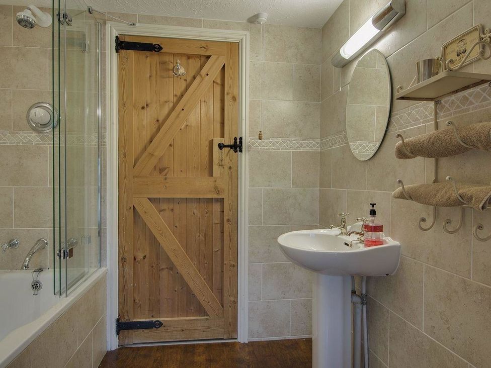 A bathroom with a bathtub and sink at Pillars in Barnstaple