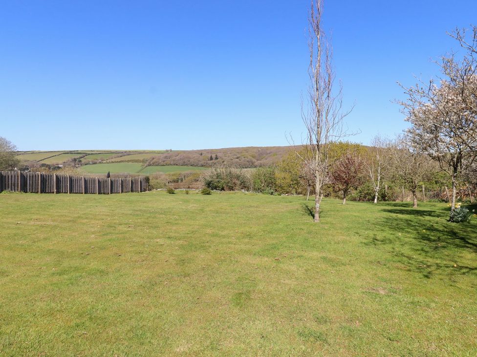 A garden with trees and a fence at Pillars in Barnstaple