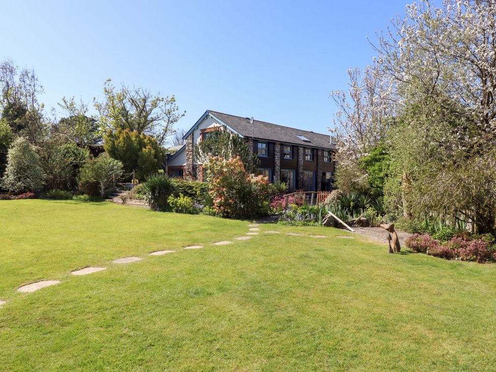 A garden with a house in the background at Pillars in Barnstaple