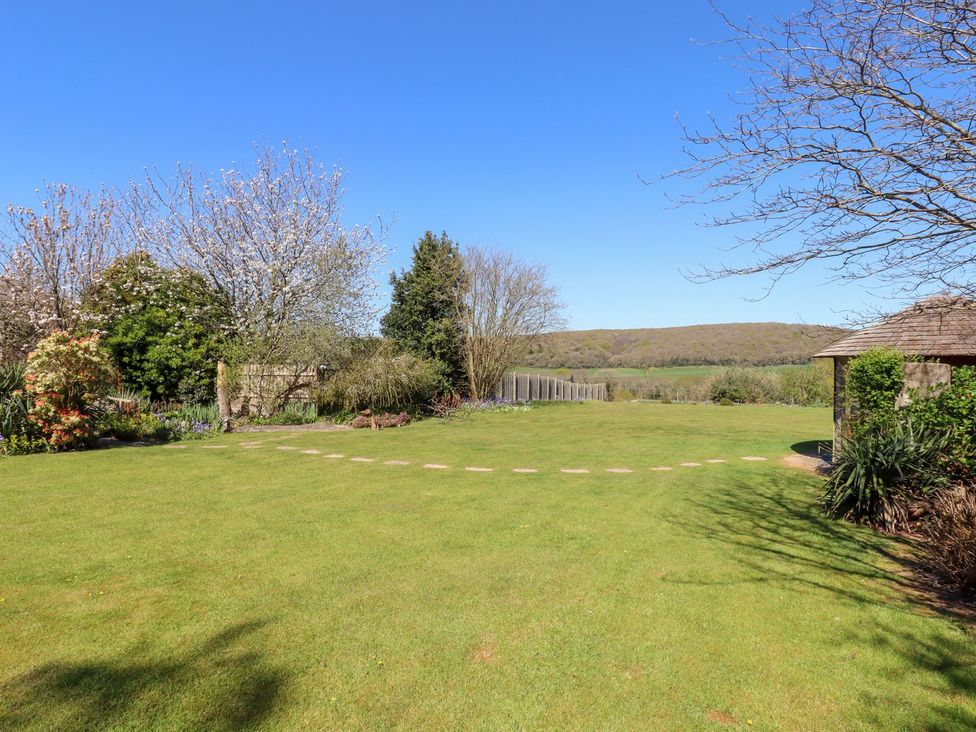 A garden with grass and trees at Pillars Barnstaple