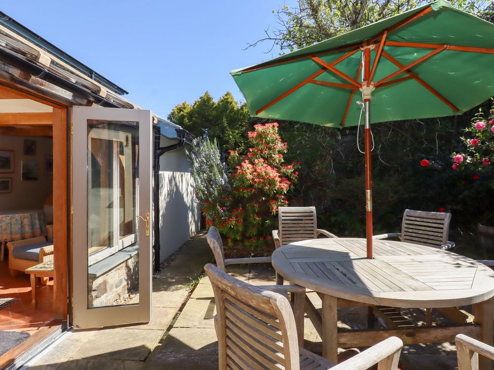 An outdoor area with a table and chairs under an umbrella at Pillars in Barnstaple