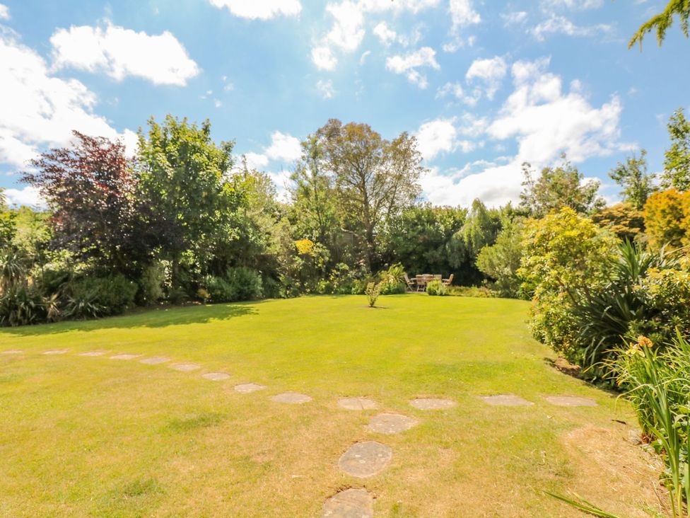 A garden with a pathway and benches at Pillars in Barnstaple