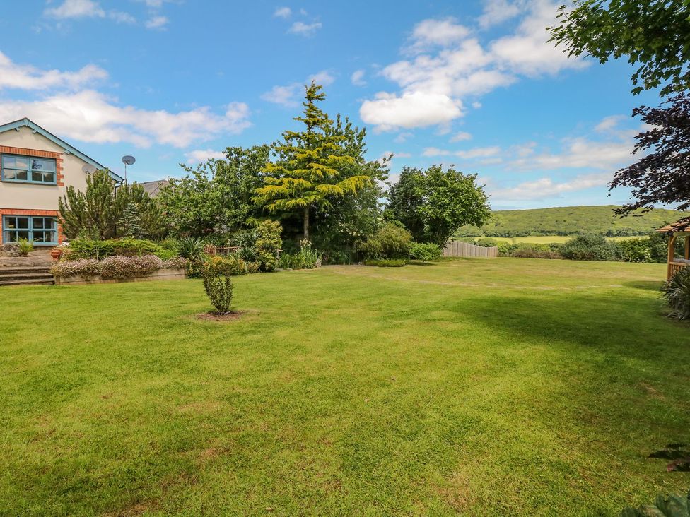 A garden with lush grass and trees at Pillars in Barnstaple
