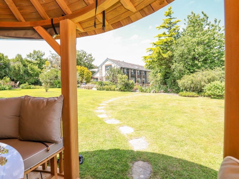 A garden with a gazebo and house in the background at Pillars in Barnstaple