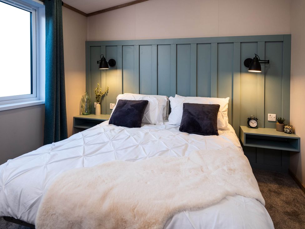 A bedroom with a large bed and bedside tables at No 8 Sandstone Lodge Sanctuary in Northwich