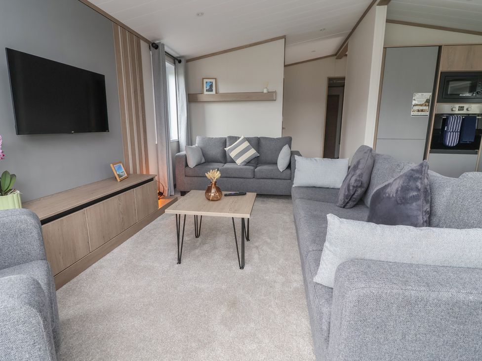 A living room with a television and sofa at Cedar Lodge 3 Bedrooms Delamere