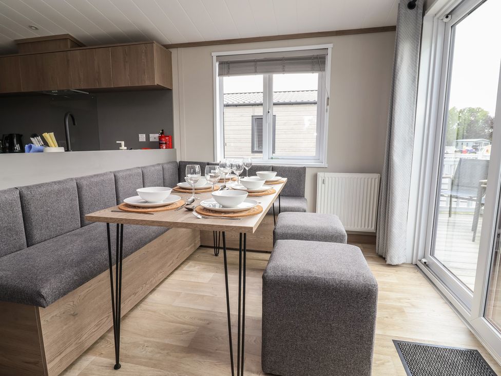 A dining area with a table set for meals at Cedar Lodge 3 Bedrooms in Delamere
