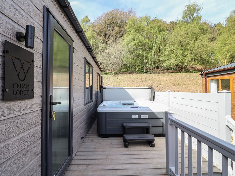 An outdoor area with a hot tub and seating at No.11 - Cedar Lodge, Delamere