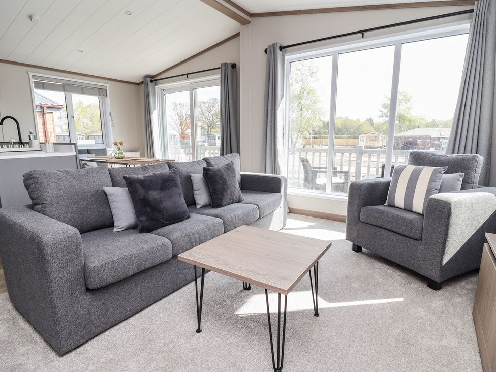 A living room with a sofa and armchair at No.11 - Cedar Lodge in Delamere