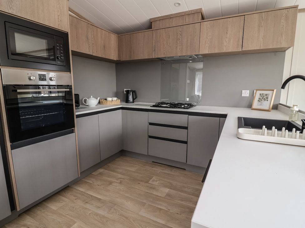A kitchen with appliances and cabinetry at No.11 - Cedar Lodge in Delamere