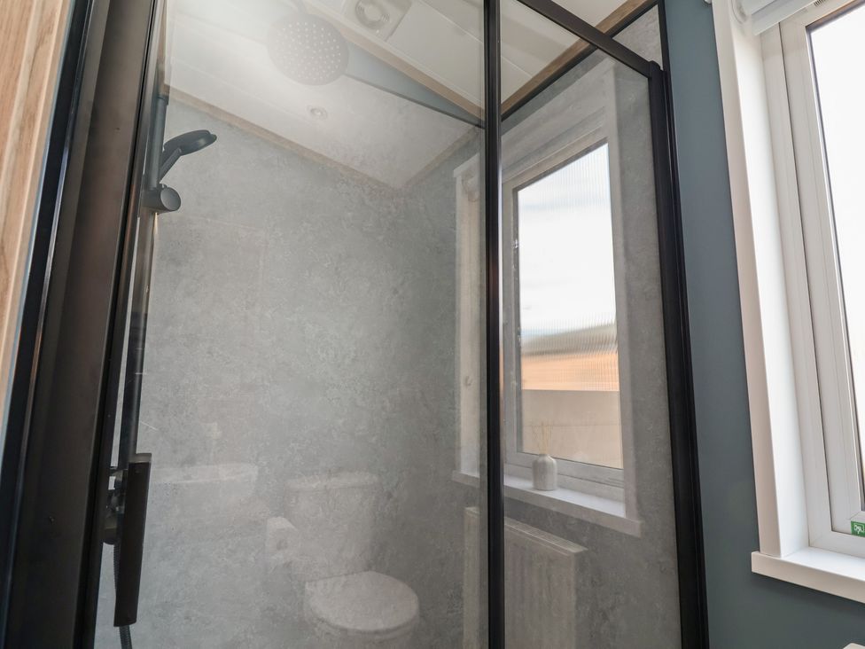 A shower with a toilet and window in the bathroom at No.11 - Cedar Lodge in Delamere
