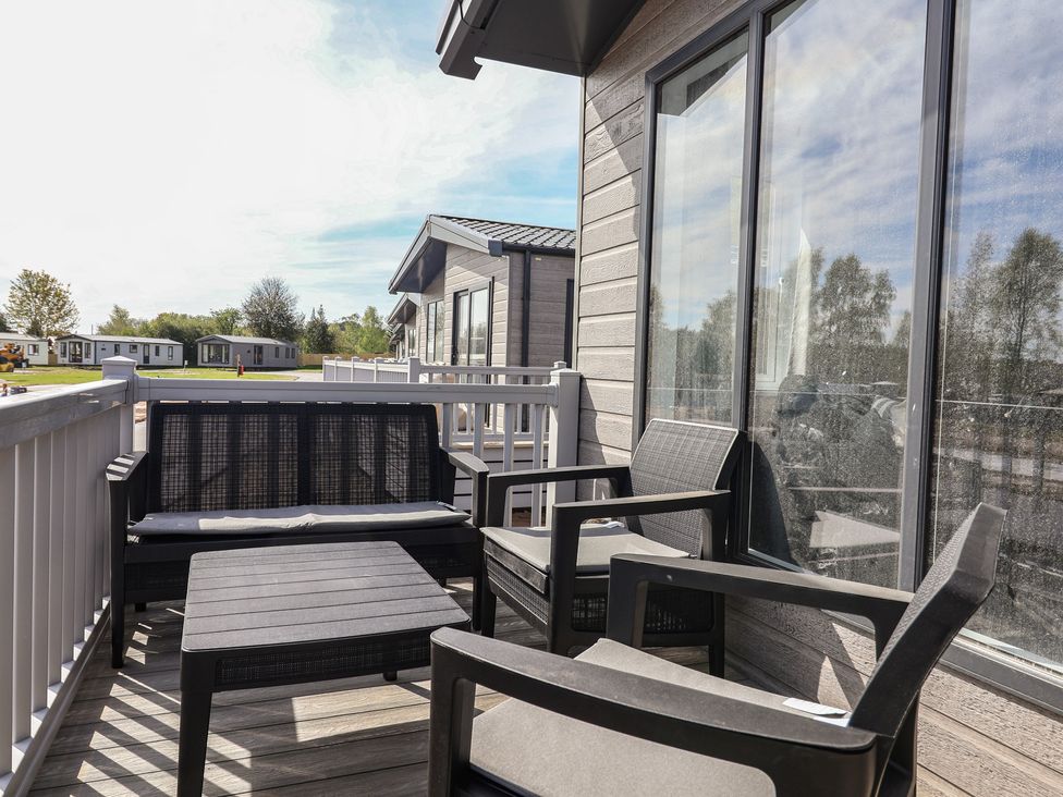 A balcony with chairs and a table at No.11 - Cedar Lodge in Delamere