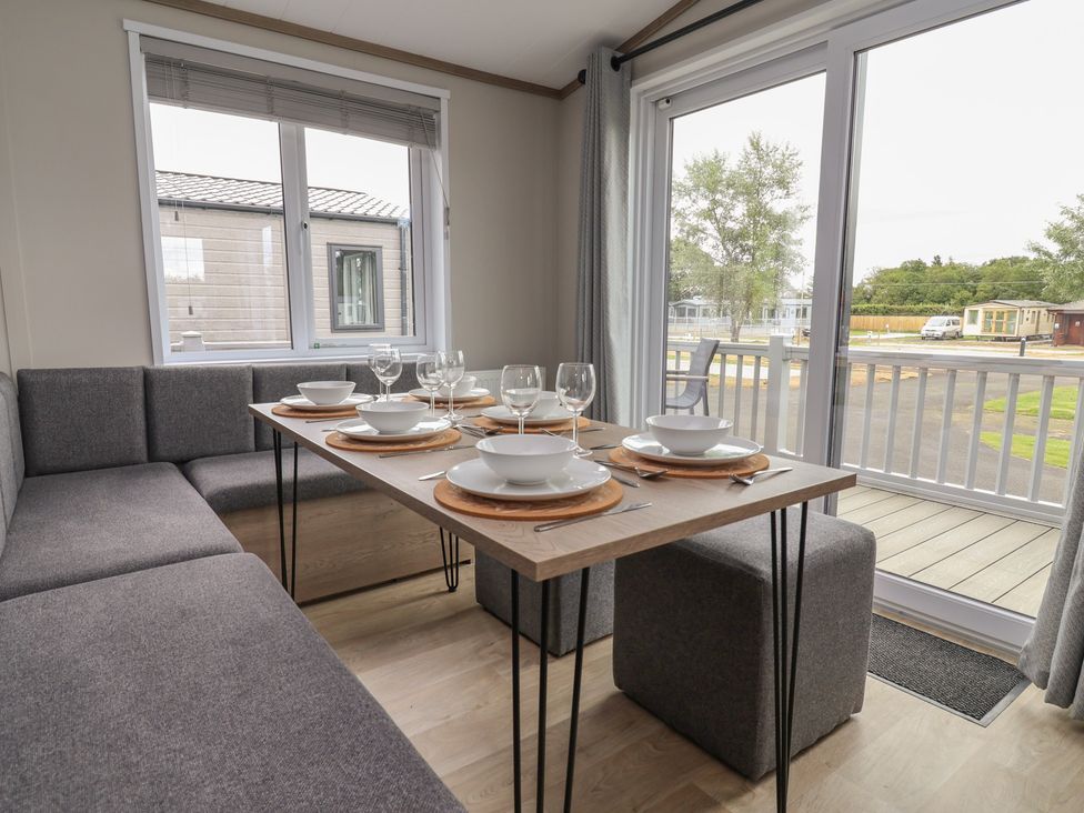 A dining area with a table set for meals at Cedar Lodge 3 Bedrooms with hot tub Delamere