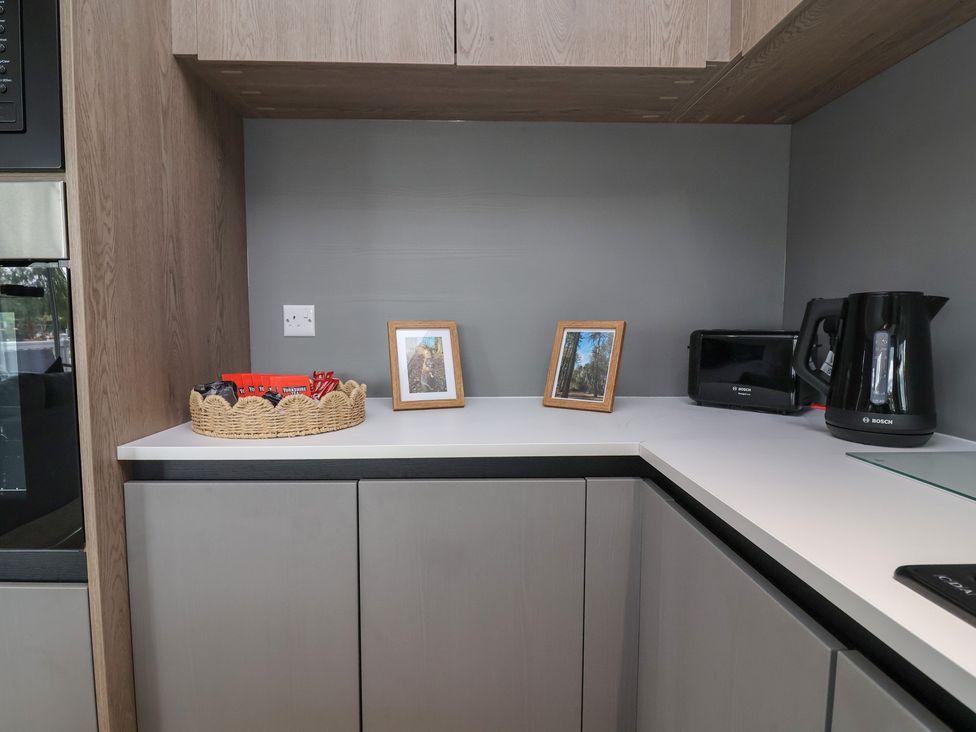 A kitchen with a countertop, photo frames, kettle, and toaster at Cedar Lodge 3 Bedrooms with hot tub, Delamere