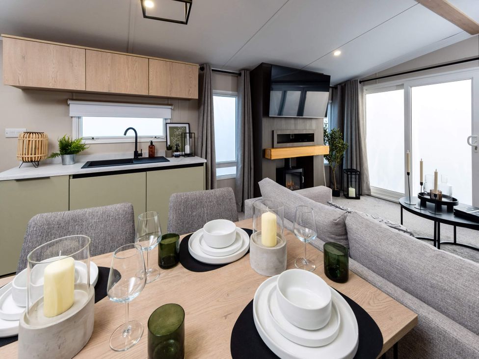 A dining room with a table and kitchen area at Arlington 40 x 14 Three Bed - 2, Northwich