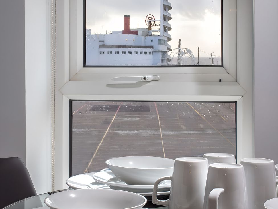 A kitchen window showing dishes and outdoor view at Apartment 3 in Blackpool