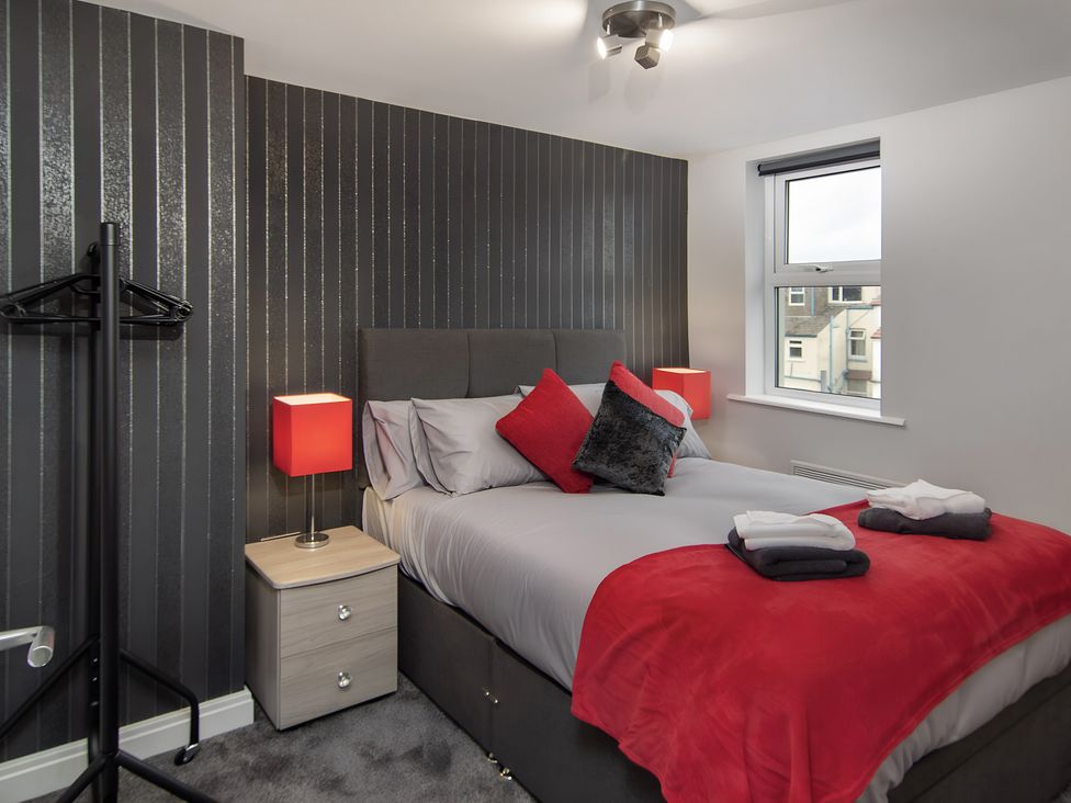 A bedroom with a bed and a bedside table at Apartment 3 in Blackpool