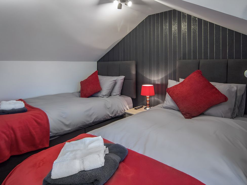 A bedroom with two beds and a bedside lamp at Apartment 3 in Blackpool