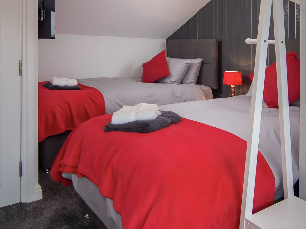 A bedroom with two single beds and a television at Apartment 3 in Blackpool