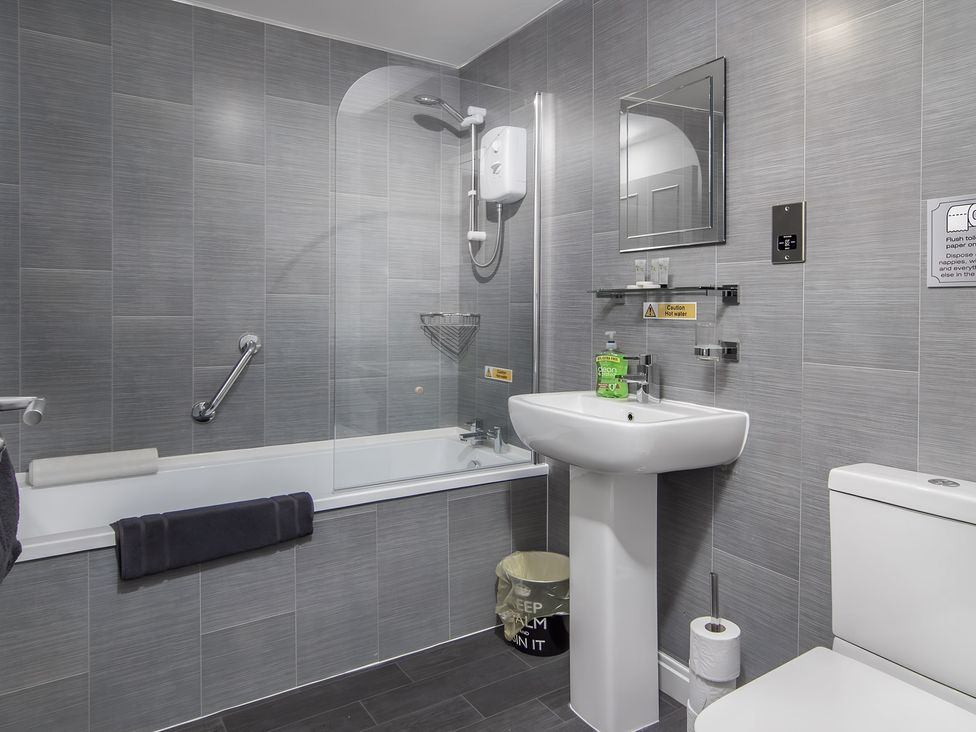 A bathroom with a bathtub and sink at Apartment 2 in Blackpool