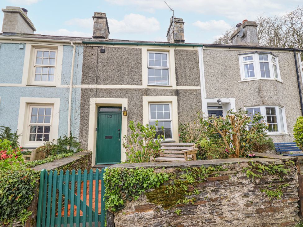 A house with a green door and plants outside at 12 Glyn Terrace in Borth-Y-Gest