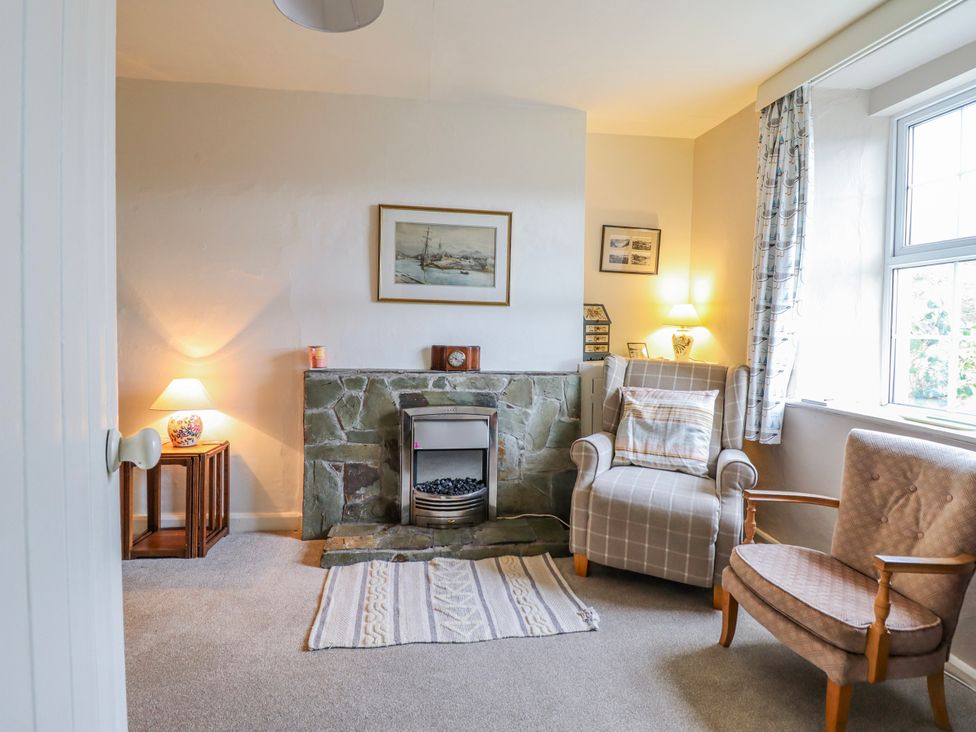 A sitting room with a fireplace and two chairs at 12 Glyn Terrace Borth-Y-Gest