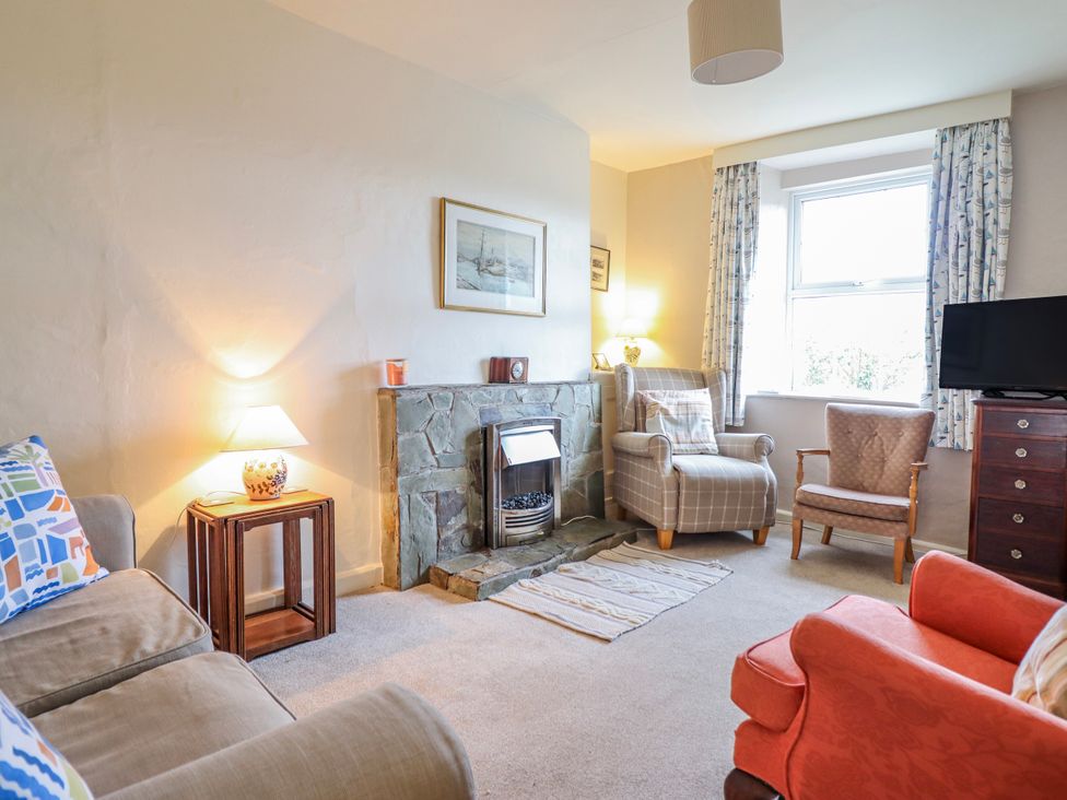 A living room with a fireplace and armchairs at 12 Glyn Terrace in Borth-Y-Gest