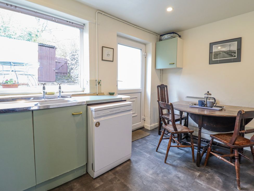 A kitchen with a sink and a table at 12 Glyn Terrace Borth-Y-Gest