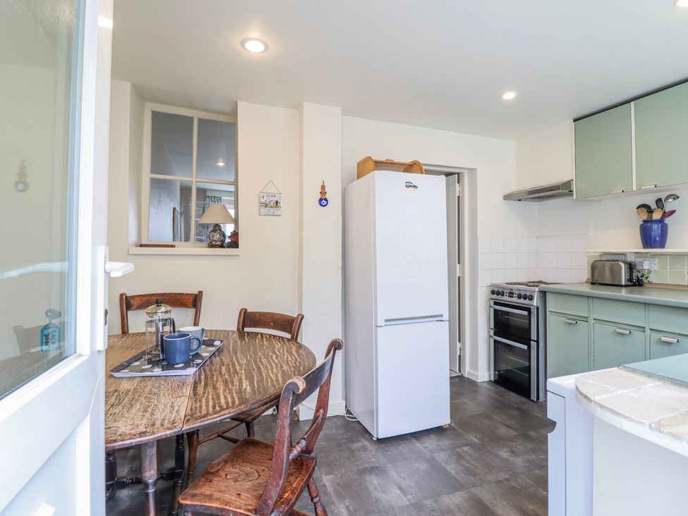 A kitchen with a dining table and chairs at 12 Glyn Terrace Borth-Y-Gest