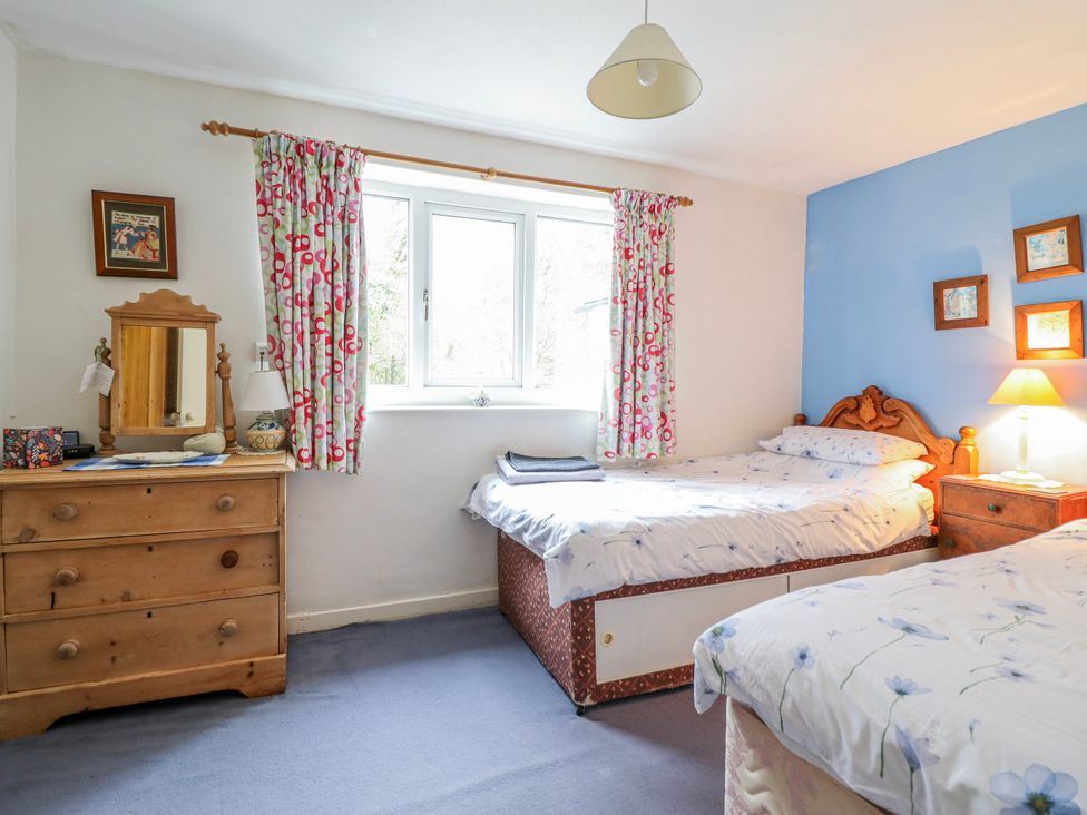 A bedroom with two beds and a mirror at 12 Glyn Terrace Borth-Y-Gest